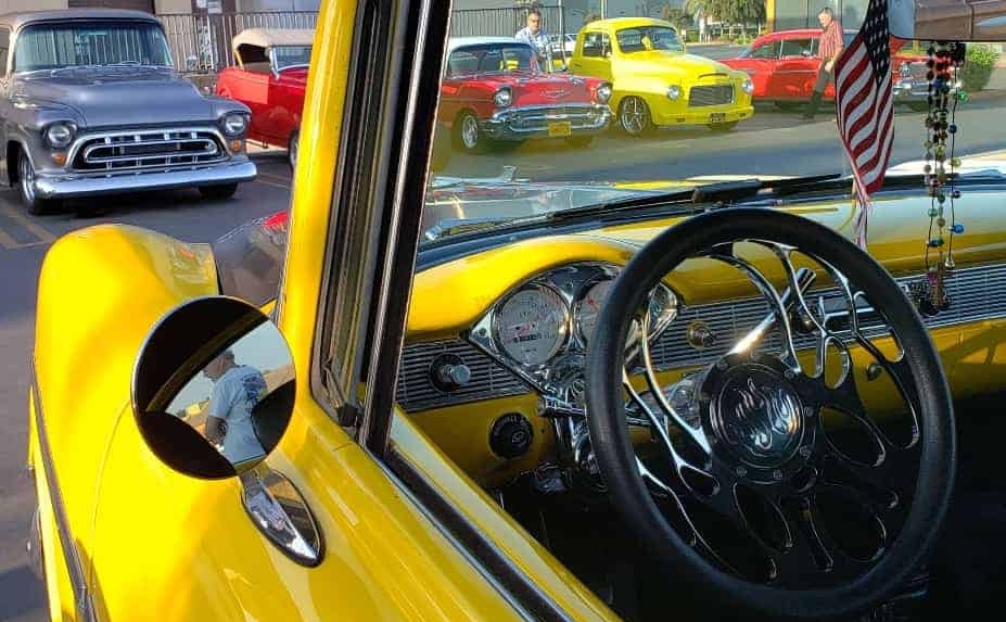 Saturday Morning Car Corral hot rods and classics through a hot rod windshield with American flag